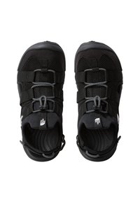 Black outdoor shoes with a mesh upper, integrated lacing system, rounded toe, and textured rubber sole, featuring a logo tag.