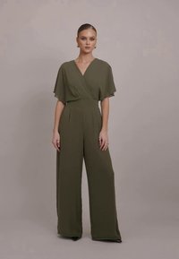 Olive green jumpsuit with wide flutter sleeves, wrap front design, and flared legs, made from a smooth, lightweight fabric.