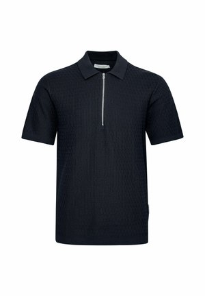 Polo de tela texturizada en azul marino oscuro, con cuello corto con cremallera y mangas cortas. Diseño simple sin patrones adicionales.