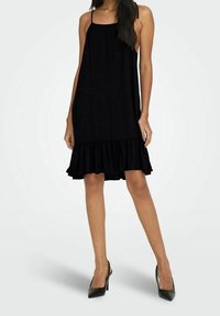 Vestido negro sin mangas con un dobladillo acampanado y con volantes, hecho de tela ligera, presenta un corte holgado y un diseño minimalista.