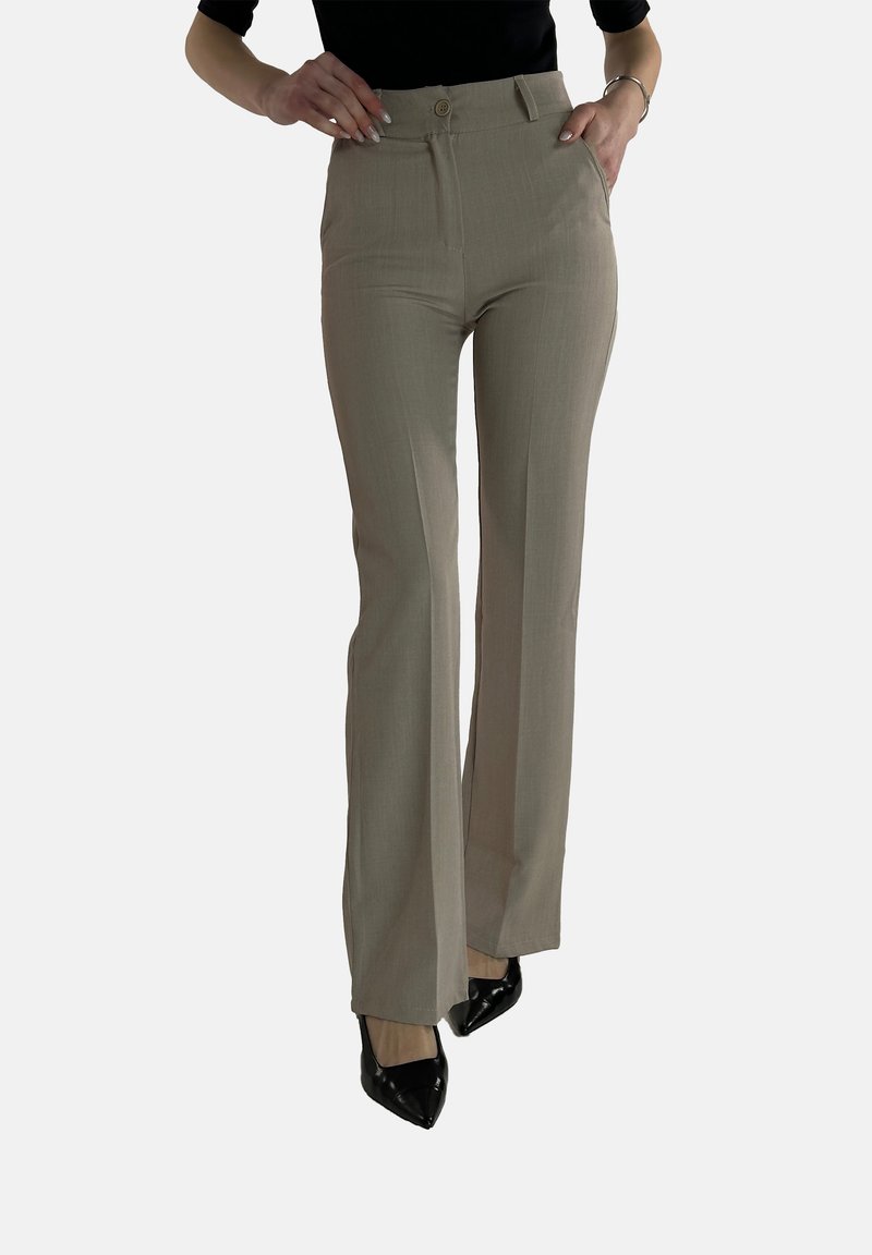 Beige high-waisted broek met een rechte pijp, subtiele textuur en voorzakken, gecombineerd met zwarte puntige hakken.