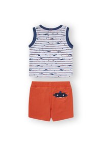 Camiseta sin mangas con ribete azul, blanca con rayas azules y estampado de tiburón. Pantalones cortos naranjas con un bolsillo estilo tiburón y cinturilla elástica.