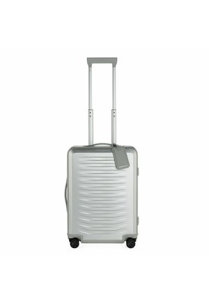 Valigia rigida argento con un design testurizzato, manico retrattile, manico laterale e quattro ruote nere per la mobilità.