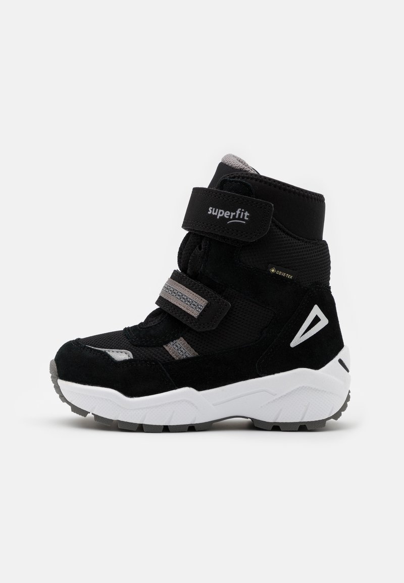 Baskets montantes noires en suède et mesh, avec des bandes Velcro et une semelle en caoutchouc blanche. Accents gris sur la tige et la semelle des chaussures.