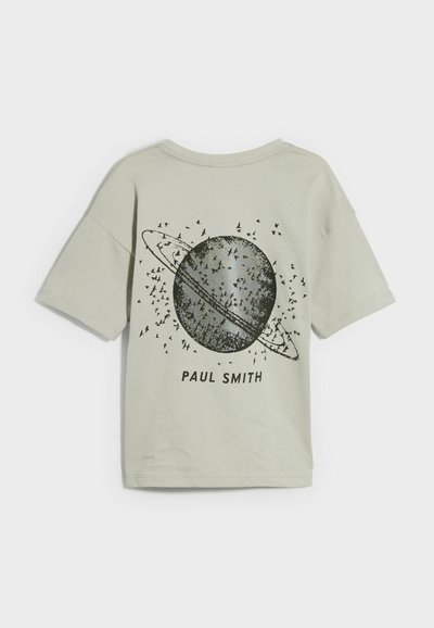 Camiseta de manga corta verde claro con un gráfico de un planeta con anillos y pájaros, con el texto "PAUL SMITH" en negro debajo del diseño.