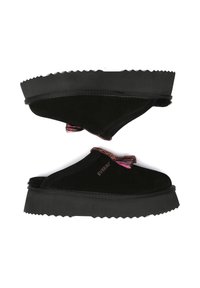 Black suede slip-on shoes with a thick black rubber sole, featuring a colorful tassel accent and textured, zigzag edge on the sole.