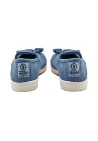 Scarpe in tela blu con una consistenza morbida, suole piatte in gomma bianca e fiocchi di stoffa sul retro, con un marchio eco-sostenibile.