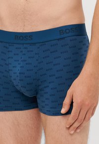 Tamno plavi bokserice od mekog materijala, sa uzorkovanim "BOSS" logom, elastičnom gumicom sa teksturiranim detaljima.