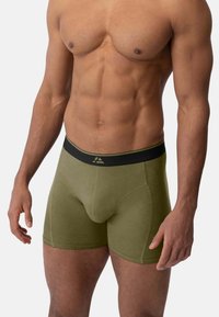 Olivově zelené boxerky z měkké tkaniny s černým elastickým pasem s logem; přiléhavý střih s výkroji na nohavicích nad středem stehna.