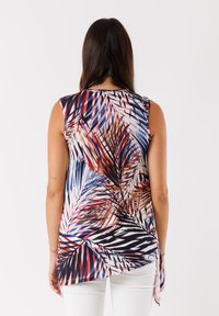 Blusa senza maniche in tessuto leggero con un vivace motivo a foglie di palma nei colori rosso, blu e crema, con orlo curvo e spacchi laterali.