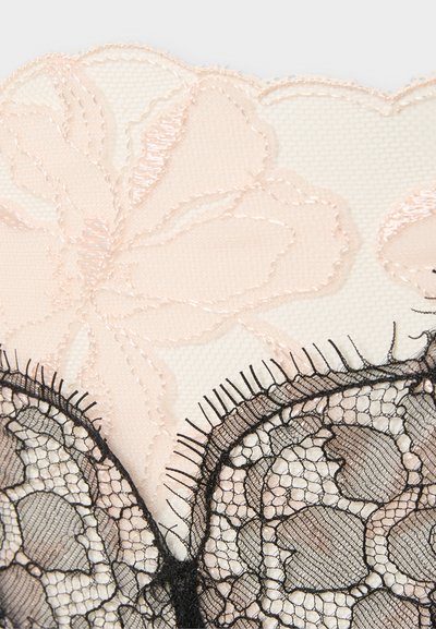 Εύθραυστη μπεζ δαντέλα με κεντητά λουλουδένια σχέδια και μαύρες δαντέλες με κυματιστές άκρες και πολύπλοκο δίχτυ.