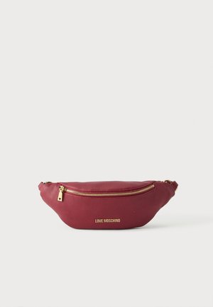 Banane en cuir rouge Love Moschino avec fermeture éclair dorée et logo sur le devant sur fond blanc.