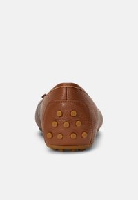 Brown leather shoe with a textured finish, featuring a rounded heel and rubber studs for grip on the sole. No laces or embellishments.