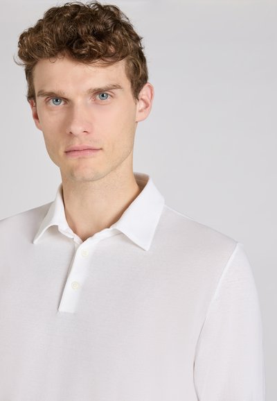 Witte kraagloze shirt met knoopsluiting, gemaakt van lichtgewicht stof, met een subtiele textuur en een ontspannen pasvorm.