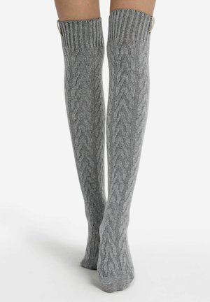 Calze a coscia grigie in maglia con un motivo a treccia testurizzato, caratterizzate da polsini a coste e dettagli metallici. Tessuto liscio e elastico per un comfort ottimale.