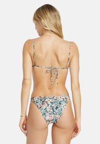 Bikini floreale multicolore, con spalline sottili regolabili e chiusura a fiocco sul retro. Il tessuto ha una consistenza liscia con un motivo vivace.