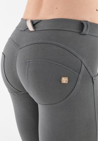 Harmaat leggingsit, joissa on istuva malli, sileä pinta ja koristeelliset takataskut pienellä logodetaljilla.