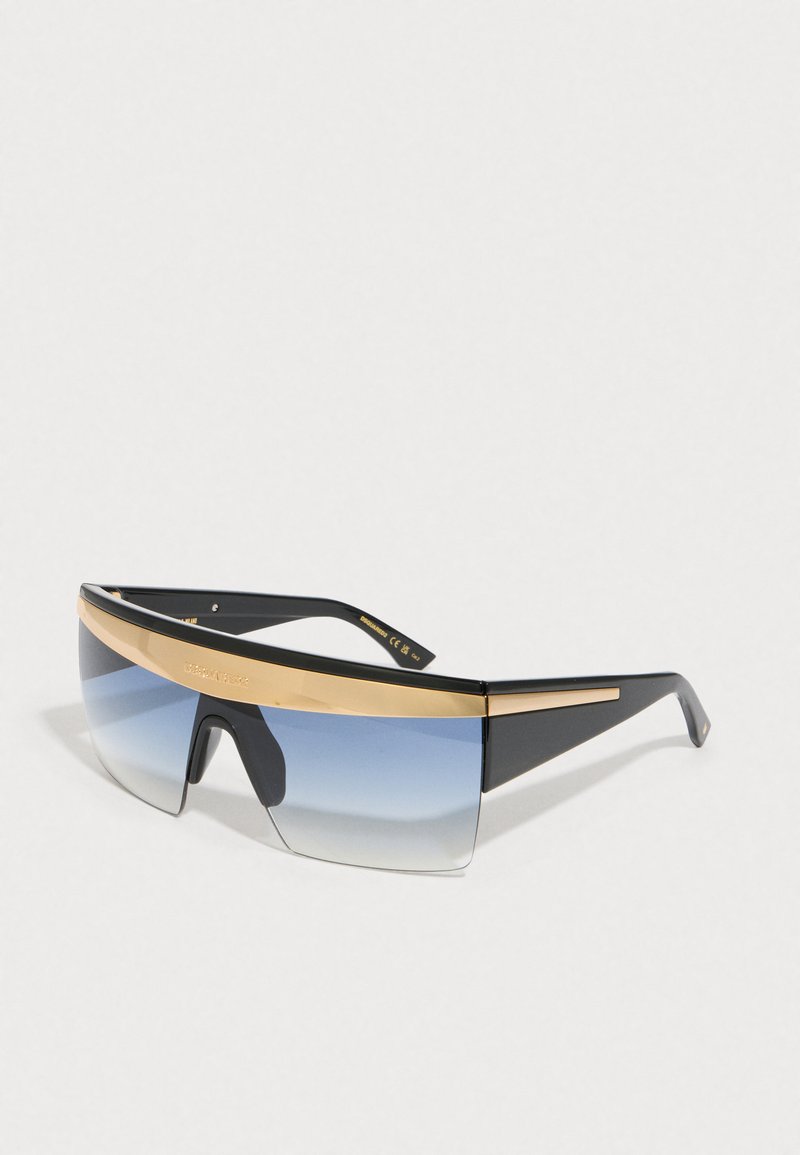 Gafas de sol con montura negra, detalle dorado en la parte superior y lentes azules degradados. Diseño angular con una forma deportiva y de gran tamaño.