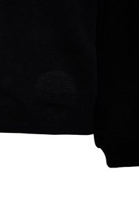 T-shirt nera con una texture liscia, caratterizzata da un motivo circolare sottile sul lato sinistro inferiore. Maniche corte, vestibilità standard.