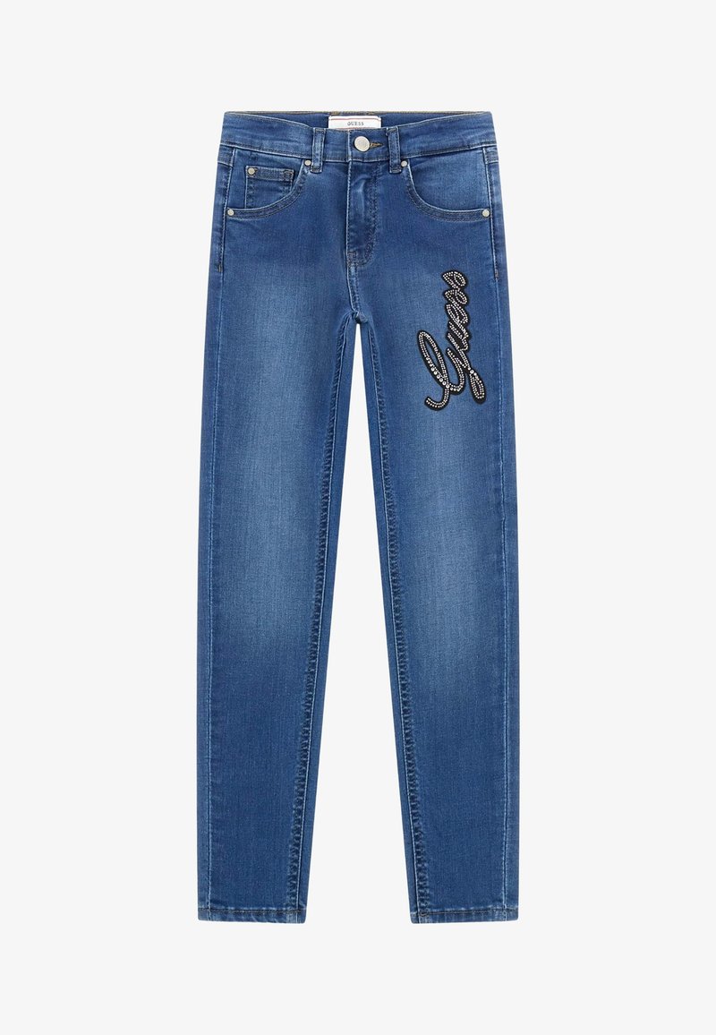 Mėlyni džinsai su siauru fasonu, ant priekinės dalies puošti blizgančiu juodu "Guess" logotipu ir standartiniu penkių kišenių dizainu.