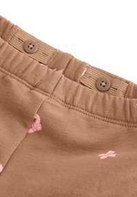Brune bomuldsshorts med elastisk talje, der har to brune knapper og små lyserøde sommerfuglemønstre over det hele.