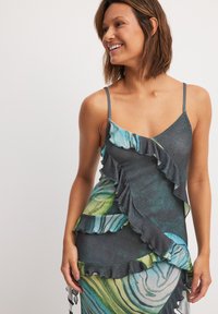 Sleeveless dress with a ruffled design, featuring a dark base, green and blue marble patterns, and a soft texture.