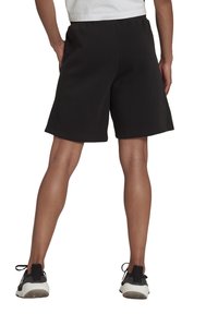 Pantalones cortos deportivos negros con una tela texturizada, una cinturilla elástica y un corte holgado, que llegan justo por encima de la rodilla.