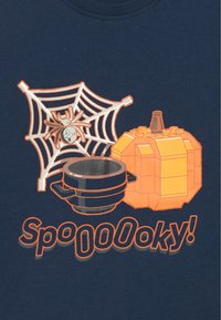 Tumši zila krekls ar oranžu zirnekli, tīklu, ķirbja lampu, katlu un tekstu "SpoooOooky!" treknrakstā.