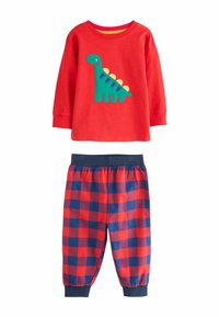 Camiseta roja de manga larga con un aplique de dinosaurio verde; pantalones de pijama de cuadros azul marino y rojo con cintura elástica y puños en los tobillos.