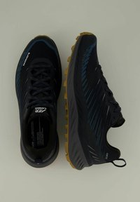 Donkerblauwe hardloopschoenen met een gestructureerde bovenkant, contrasterende zwarte accenten en een robuuste gele buitenzool. Kenmerken zijn veters en een treklus.