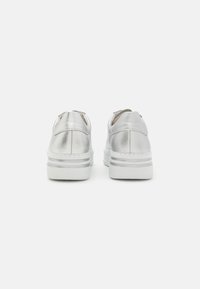 Silver metallic slip-on sneakers with a textured finish, featuring a cushioned white sole and subtle horizontal accent lines.