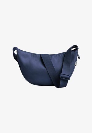 Navyblaues Stofftasche mit geschwungenem Design, verstellbarem Tragegurt, glatter Oberflächenbeschaffenheit und seitlichem Reißverschlussfach zur Aufbewahrung.