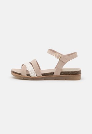 Beige sandals with a textured strap, smooth front and back straps, an adjustable ankle buckle, and a cork-textured footbed.
