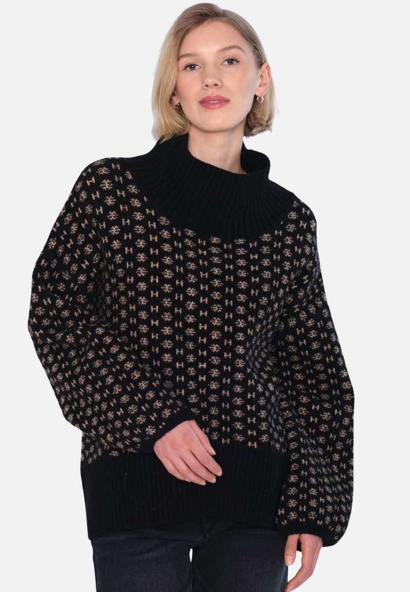 Svart stickad tröja med hög, ribbad krage och geometriskt beige mönster; lös passform med vida ärmar och ribbad nederkant.