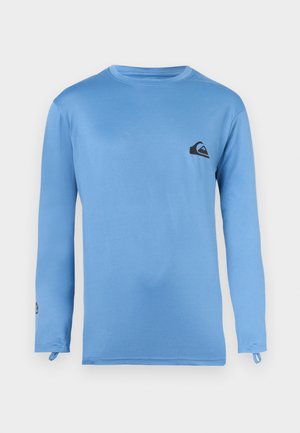 Hellblaues Langarmshirt mit Rundhalsausschnitt, kleinem schwarzem Logo auf der linken Brust und Daumenschlaufen an den Bündchen.