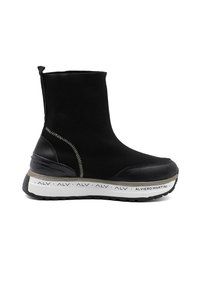Zwarte instapboot met een ribbelgebreid bovenwerk, gladde leren accenten, een dikke gestructureerde zool en een gemerkte witte middenzool.