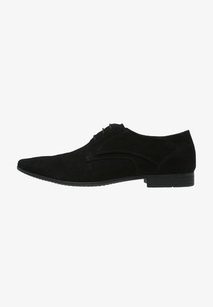Chaussure habillée pour homme en daim noir à lacets, bout pointu et talon bas, vue de profil extérieur sur fond blanc.