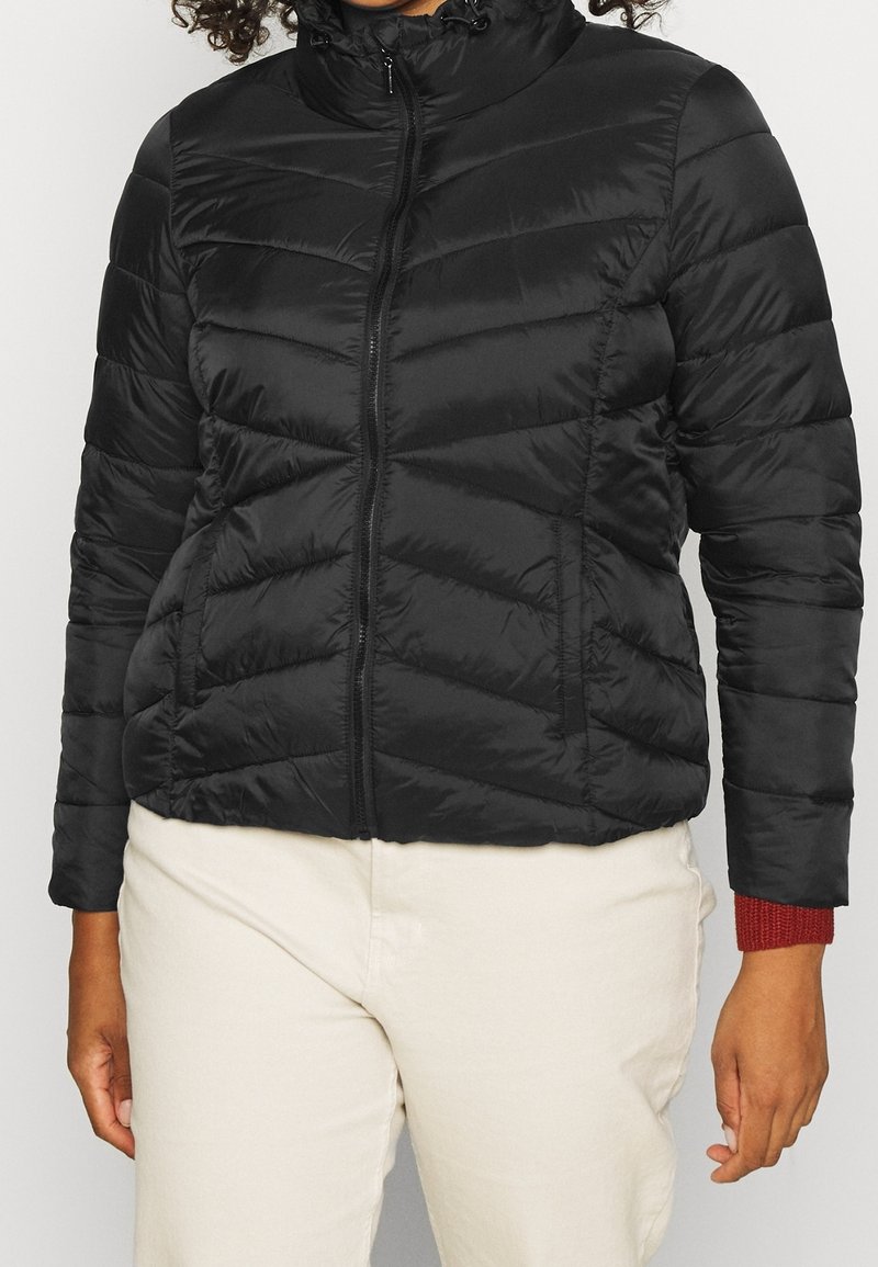 Schwarze Daunenjacke mit Reißverschluss, hohem Kragen und zackenförmiger Steppung. Verfügt über rote Akzente an den Bündchen. Weiches, leichtes Material.
