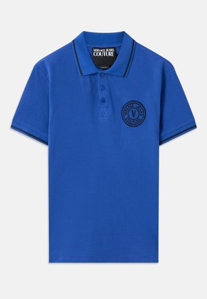 Blue polo shirt with a slim fit, featuring a collar, three-button placket, and a round logo patch on the chest. Black trim accents.