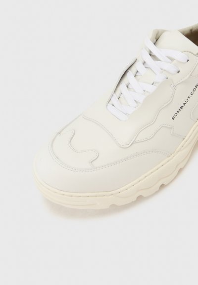 Λευκό δερμάτινο αθλητικό παπούτσι με λευκά κορδόνια, παχιά σόλα, διακοσμητική ραφή και την επιγραφή "ROMBAUT" στο πλάι.