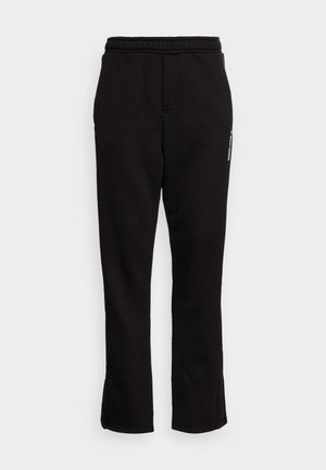 Pantalon de survêtement noir avec une taille élastique, deux poches latérales et une coupe ajustée effilée. Présente un logo blanc subtil imprimé sur le côté.
