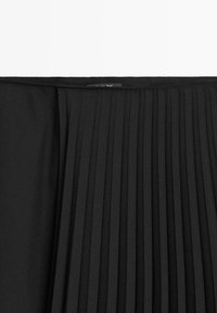 Zwarte geplooide rok met een brede elastische tailleband en textuurstof, met verticale plooien en een gladde afwerking.