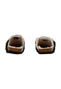 Zapatos negros sin cordones con un interior forrado de pelo y suelas planas de corcho. Presentan un exterior texturizado y un diseño sencillo.