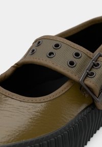 Oliviroheline kinga läikiva viimistlusega, millel on lai rihm silmade ja metallist pandlaga ning sooneline must tall.