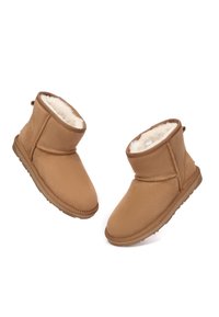 Brown ankle boots made of soft suede with a faux fur lining and rubber soles. The design features a curved top and a decorative seam.