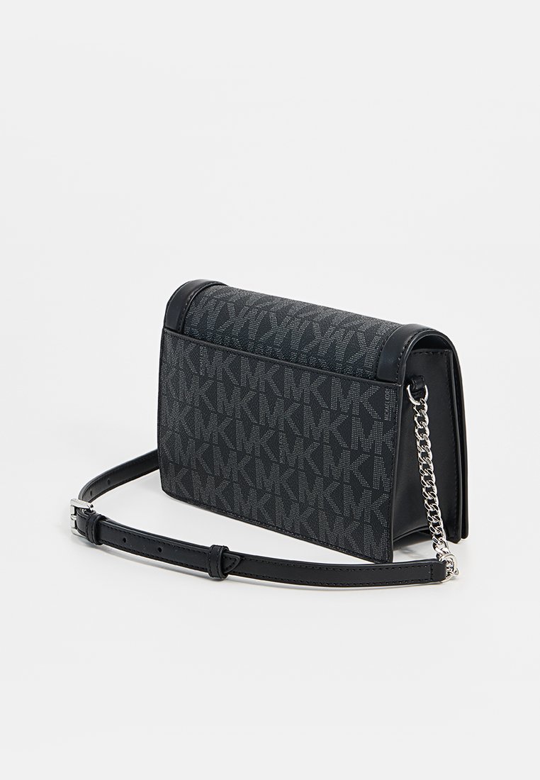 Sac bandoulière noir en synthétique avec un design structuré, mettant en avant un motif logo subtil, une bandoulière en chaîne et en cuir, et une fermeture magnétique.