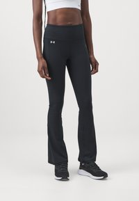 Black flared athletic pants with a high waistband, made of stretchy fabric, featuring a small white logo on the left hip.
