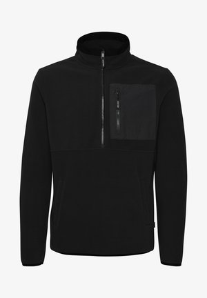 Must musta pullover kõrge kraega, pooltõmbega ja esise külje taskuga, millel on tõmblukk. Sile ja soe tekstuur.