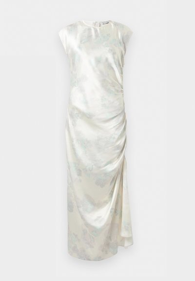 Μακρύ, αμάνικο σατέν φόρεμα σε απαλό κρεμ χρώμα με διακριτικό λουλουδένιο μοτίβο και ραμμένη λεπτομέρεια στη μία πλευρά.