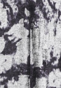 Tejido texturizado con un patrón floral en escala de grises que presenta tonos de negro y blanco. La superficie parece suave y ligeramente reflectante.
